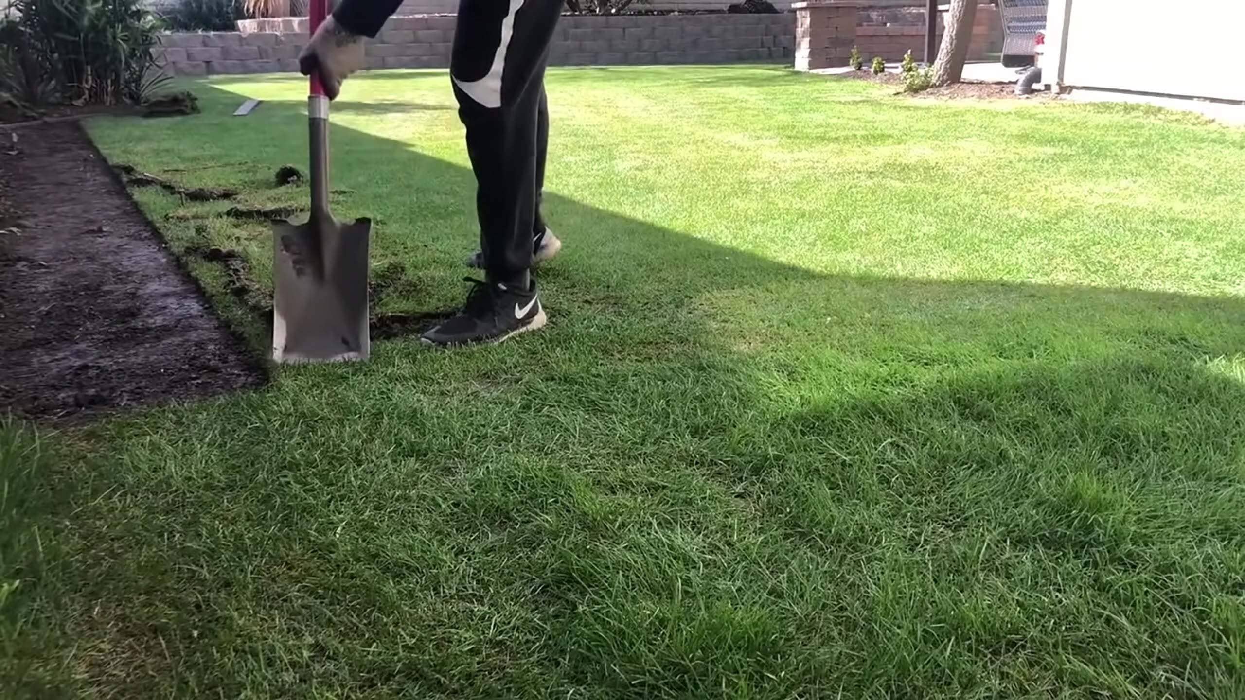 person standing on grass with pale for lawn maintenance in ct