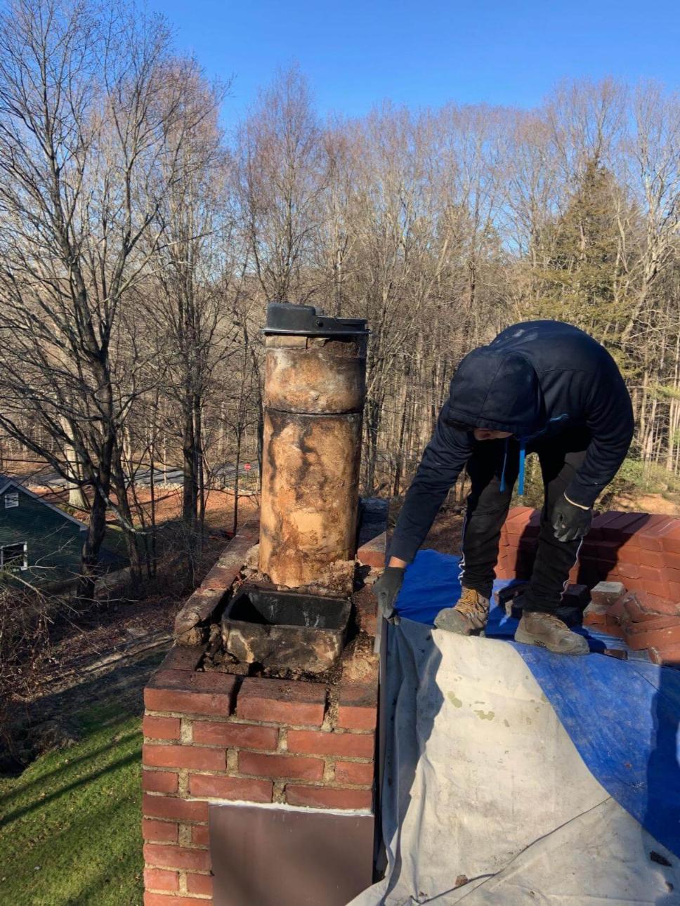 A man repairing a chimney on a roof.
