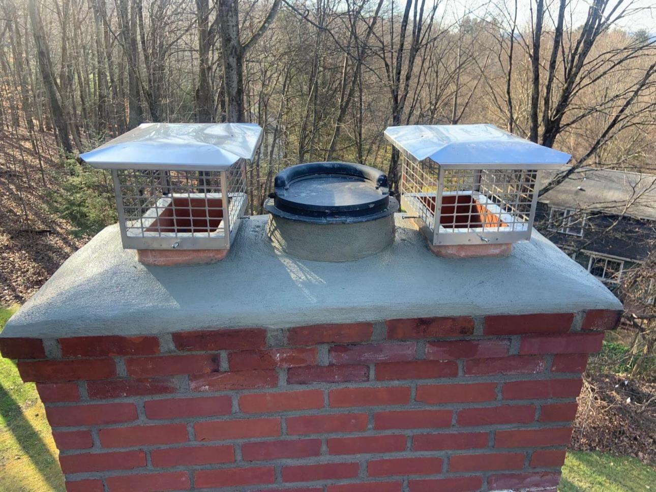 Two bird feeders on top of a brick chimney.